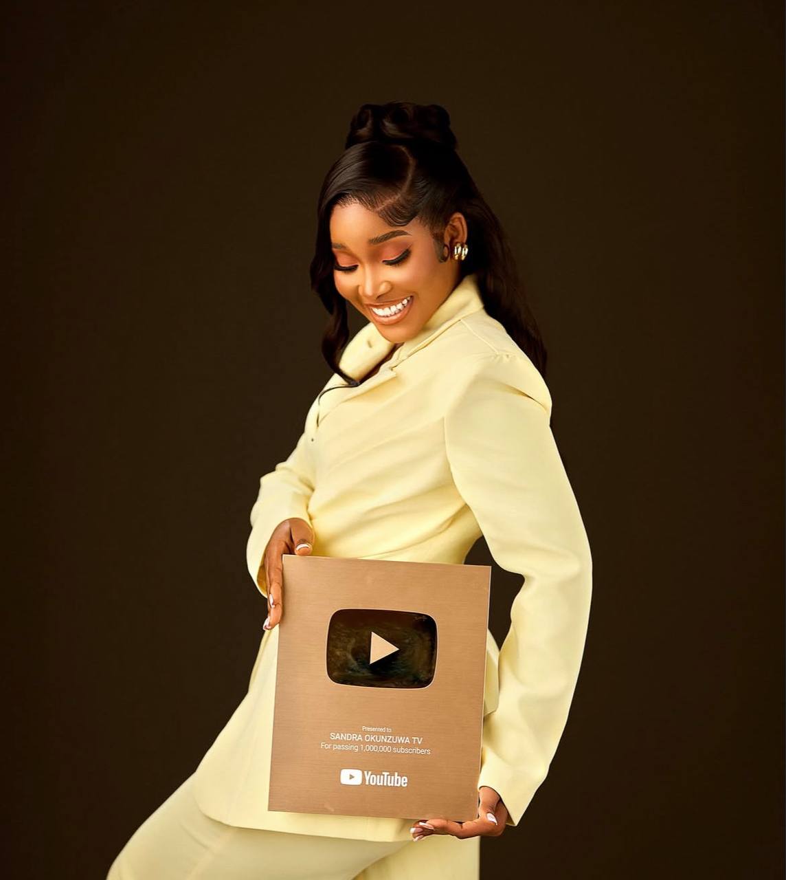 Sandra Okunzuwa holding her YouTube Gold Play Button award